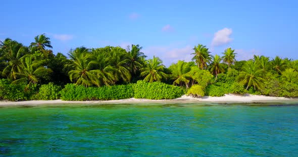 Wide angle flying travel shot of a sandy white paradise beach and blue ocean background in colourful