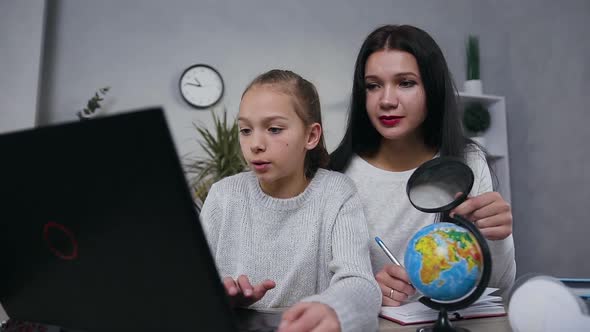 Mother and Teen Girl which Doing Together Geography Task on Computer