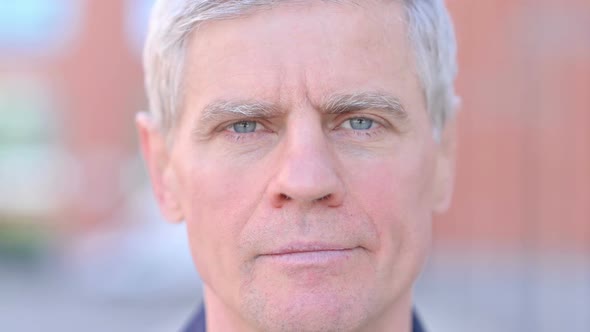 Outdoor Close Up of Serious Middle Aged Man Looking at Camera