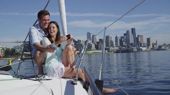 Young couple on sailboat together using cell phone. Shot on RED EPIC for high quality 4K, UHD, Ultra