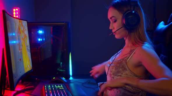 Sexy Young Gamer Woman Sitting By the PC and About To Play Video Game