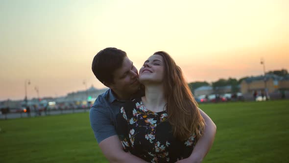 Portrait of a Loving Couple Hugging in the Park at Sunrise.