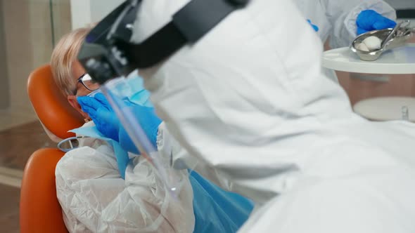 Elderly Woman with Protection Suit Touching Face Having Toothache