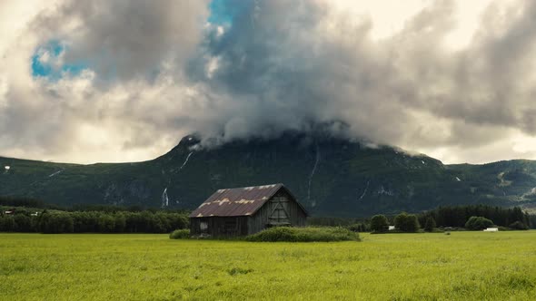 Scenic View Of A Deserted Wooden Barnhouse On The Green Meadows In Hemsedal With Gray Clouds Soaring