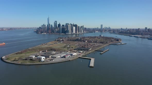 An aerial view of New York harbor on a sunny day with blue skies and no clouds. The camera truck rig