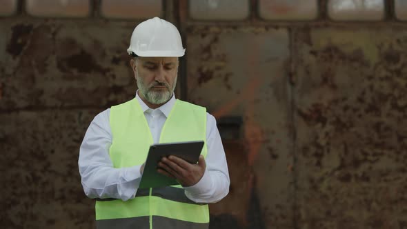 Worker Using Tablet and Walking at Construction Area