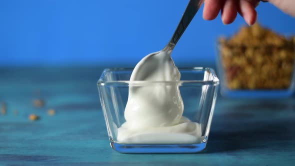 Putting Greek yogurt into the glass bowl