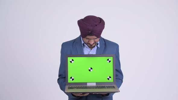 Happy Bearded Indian Sikh Businessman Showing Laptop