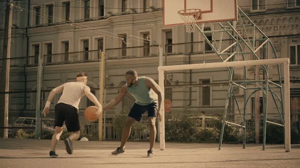 White and Black Men Playing Basketball