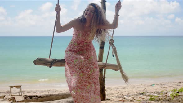 Cheerful Woman Riding Self Made Swing on Beach