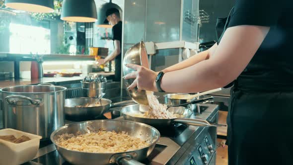 Kitchen Worker is Rearranging Rice Between Bowls