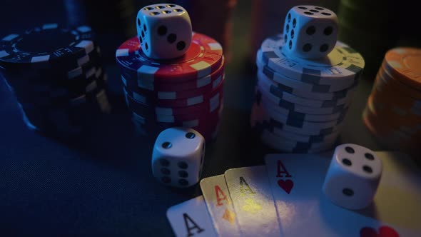 Casino Chips with Dice and Playing Cards on a Dark Table