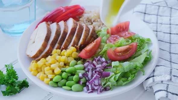 Grilled chicken breast with brown rice and vegetables in white plate