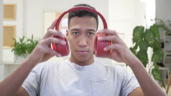 African Man Wearing Red Headphones for Listening Music