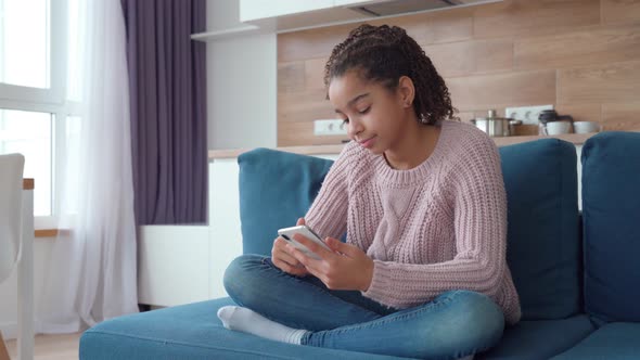 Portrait of Happy Smiling African American Teen Girl Using Smartphone at Home