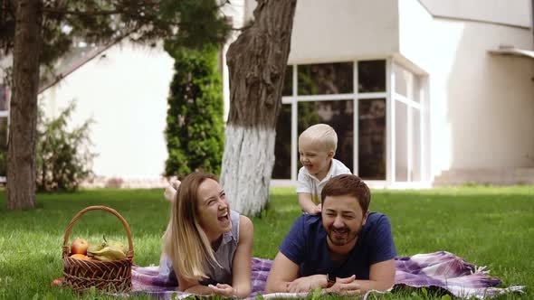 Happy Joyful Young Family Father Mother and Little Son Having Fun Outdoors Playing Together in