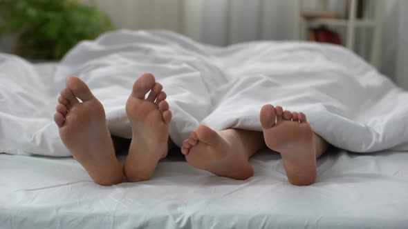 Womans Feet Flirting With Man in Bed, Couple Having Intimate Problem, Relations