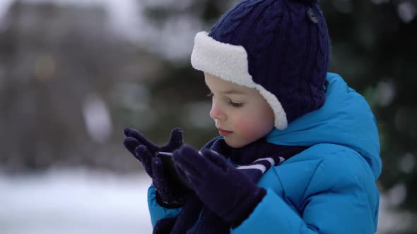 Little Boy in Winter Wear Using Phone on Cold Snowy Day