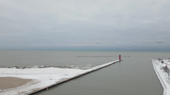 Aerial view of Lake Michigan with ice covering pier out to lighthouse.