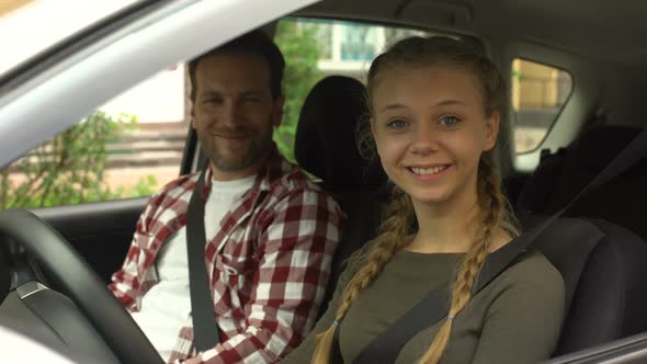 Happy Female Smiling Into Camera, Sitting in Car With Instructor, Driving School