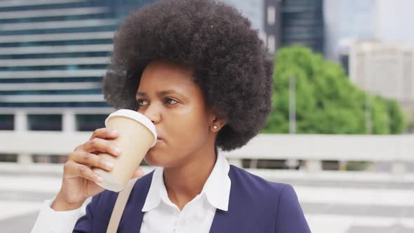 African american businesswoman drinking takeaway coffee in city