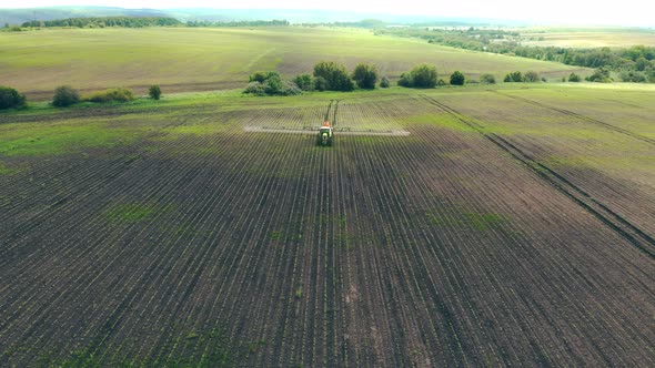 Aerial View Farm Machinery Spraying Insecticide To the Green Field, Agricultural Natural Seasonal