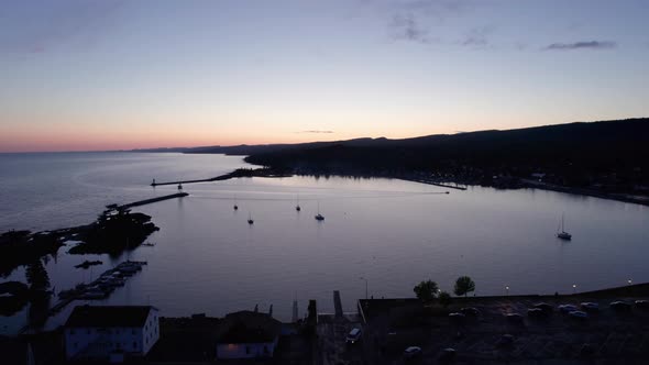 Sunset drone shot over grand marais in the summer showing the harbor