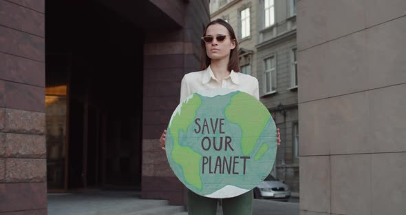 Millennial Girl in Glasses Holding Model of Earth with Writing Save Our planet.Young Woman in
