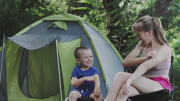 Mom and her son to itching after mosquito bites sitiing near tent.