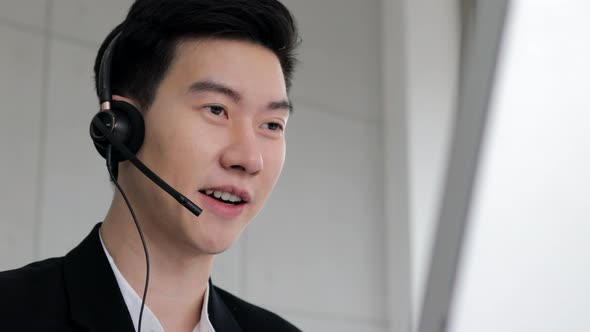 smart guy call center wear headset and working with computer while consulting customer