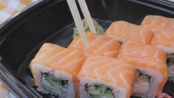 A Girl Has Rolls and Sushi in a Chinese or Japanese Restaurant