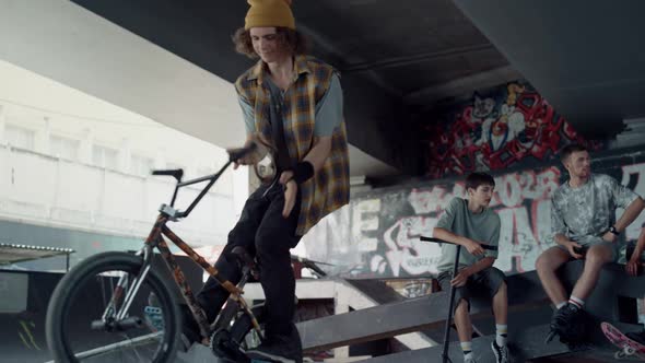 Active Man Practicing Bmx Bicycle at Skate Park with Graffiti on Wall