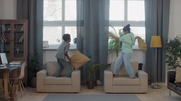 Mixed-Race Siblings Pillow-Fighting In Living Room