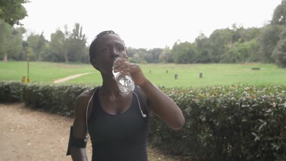 hydration,sport,training.African black athlete drinks water in the park