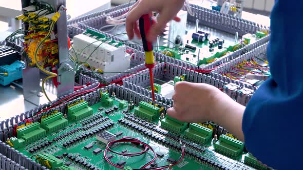 Close Up of Electrician Working with Cables and Wires on the Assembly Line the Installation of the