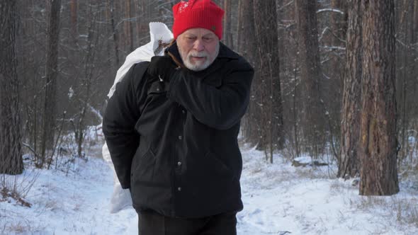 Bearded Pensioner Walks Along Forest Road Holding Bag