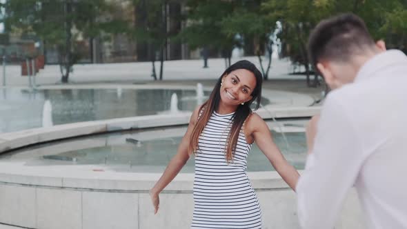 Young Man Taking Photo of His Beautiful Black Girlfriend in City Center