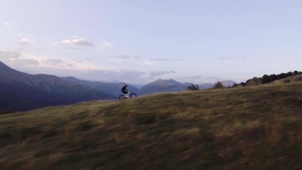 Biker Trail Ride on Offroad Path By Mountain Bike in Summer Sunny Day Approaching Sunset or Sunrise