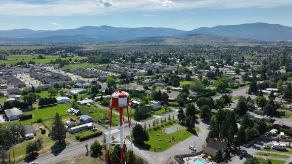 Orbiting aerial shot of a water tower in middle class America.