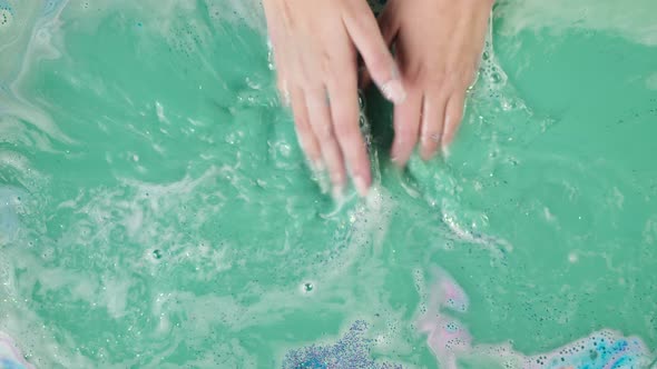 Hands Touching Blue Water Closeup Dissolved Bath Bomb