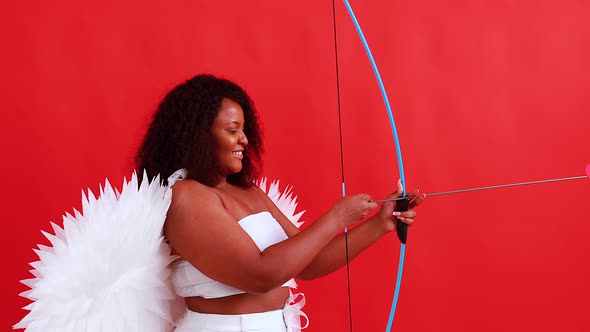 African Latin Cupid Woman in Wtite Top Bra Holding Bow and Arrow in Red Studio The 14Th of February