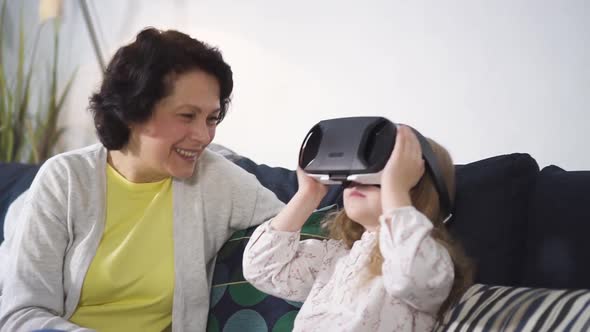 Grandchild Is Playing with New Digital Technology of Virtual Reality Simulation Glasses