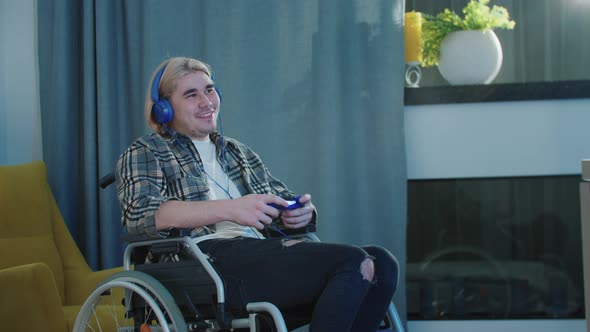 Blonde Man in a Wheelchair Playing Game Using a Joystick
