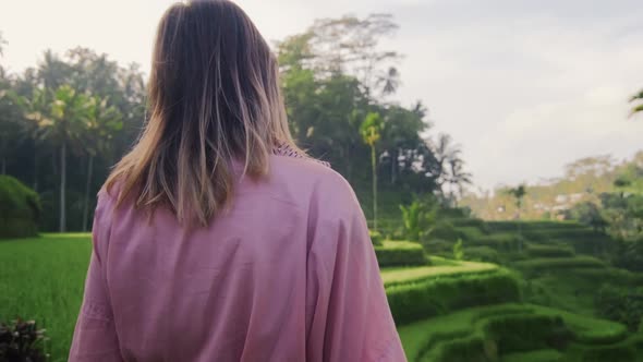 Young Woman in Pink Kimono Walking in Rice Fields Bali. Fashion Style