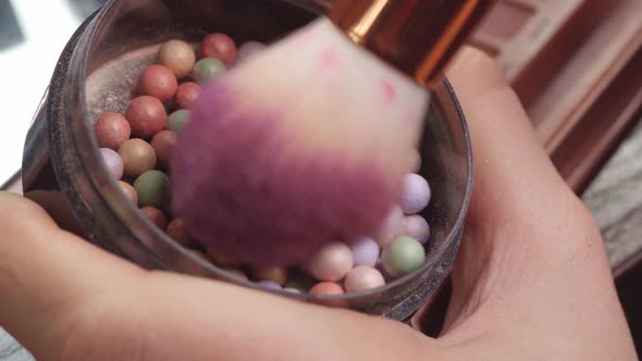 Makeup Brush Applying Cosmetic Powder Balls on Vanity Table Close Up