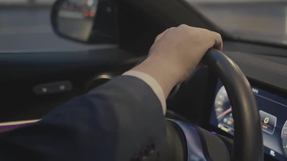 Closeup of Male Hands in Costume on Steering Wheel Car