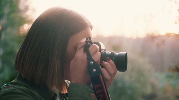 Girl photographing at sunset, close up, hand held