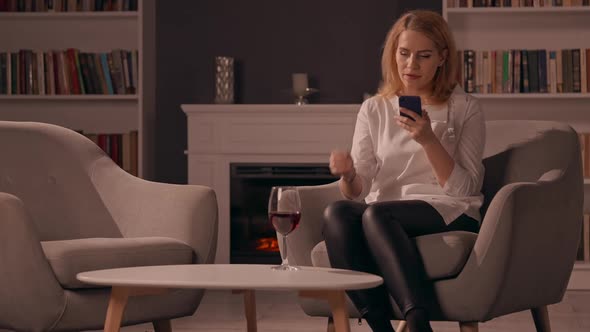 Caucasian Adult Female Using Smartphone in Living Room
