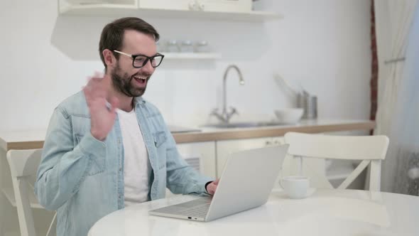 Beard Young Man Doing Video Chat on Laptop in Office