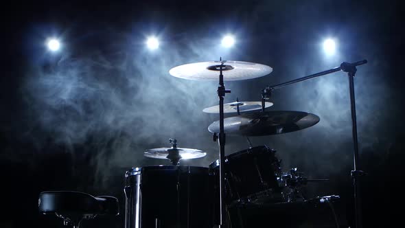 Professional Drum Set with Chair. Black Smoky Background. Back Light. Side View